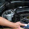 Technician cleaning a car engine