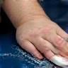Close-up of hands applying wax on car hood